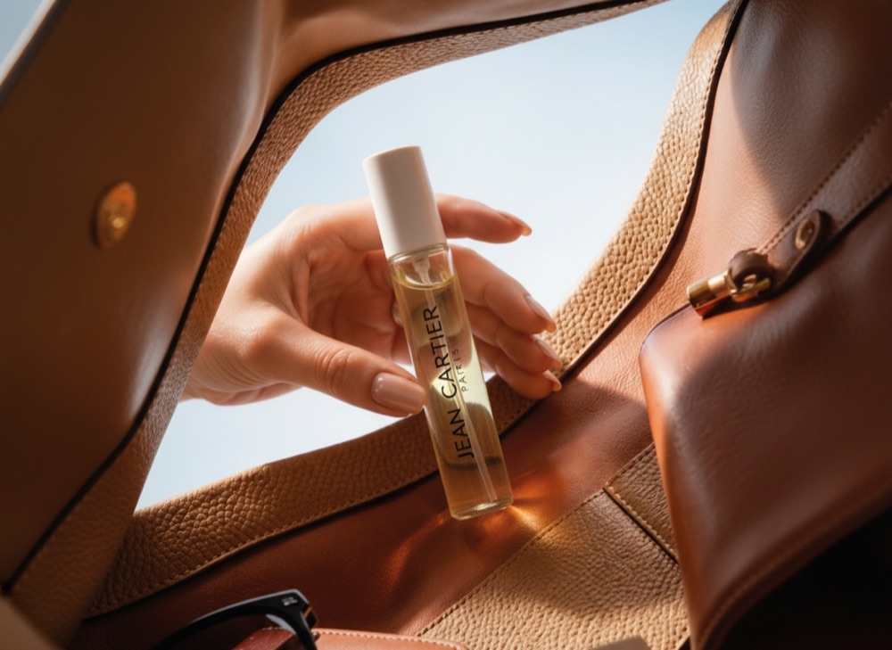 Perfumero roll-on de 12 ml de Jean Cartier saliendo de una cartera